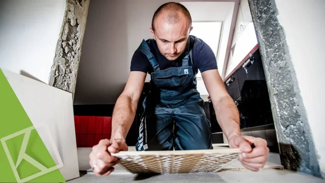 decorare con grandi lastre di gres - immagine di un posatore alle prese con una piastrella