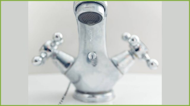 rubinetto che perde una goccia d'acqua in primo piano