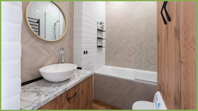 4 principi chiave di Arredare Bagno per un bagno piccolo di successo - esempio di un bagno piccolo con specchio e lavabo sulla sinistra, vasca sullo sfondo e piccolo armadio porta oggetti sulla destra